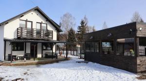 a house with snow in front of it at VILA RAISA in Neagra Şarului