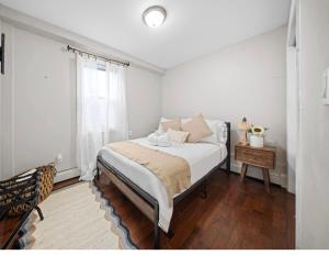 a white bedroom with a bed and a window at NYNJ World Cup 26 Fan Zone Queens Kasa Boho Rentals Sleeps 4 persons in Brooklyn Manor