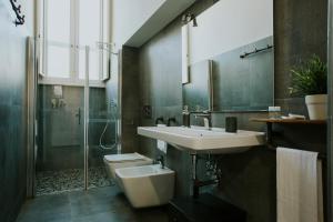 een badkamer met een wastafel, een toilet en een douche bij Loft 291 in Matera