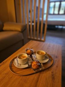 a tray with two cups of coffee and pastries on a table at El Camarote in Cudillero