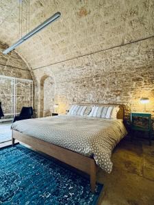ein Schlafzimmer mit einem Bett in einer Ziegelwand in der Unterkunft Il Magazzeno della Prozia in Corato