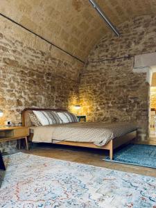 a bedroom with a bed in a brick wall at Il Magazzeno della Prozia in Corato