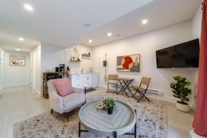 a living room with a couch a table and a tv at Chic Hideaway-King Bed-Fireplace-DT-WEM-Garage in Edmonton