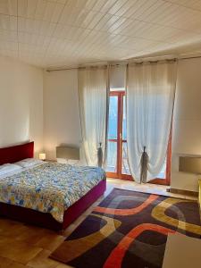 a bedroom with a bed and a large window at Appartamento sul Lago con Terrazza Panoramica in Riva di Solto
