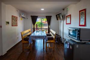 a dining room with a table and chairs and a television at El Triunfo Apart - Departamentos Equipados Potrero de los Funes in Potrero de los Funes