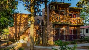 an apartment building with a balcony and trees at El Triunfo Apart - Departamentos Equipados Potrero de los Funes in Potrero de los Funes