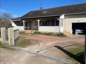 a house with a dog sitting in the garage at Voyage in Ouroux-sur-Saône