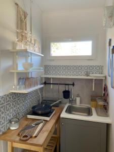 a small kitchen with a sink and a window at Bánhiday M4 Weekendhouse in Balatonakarattya +8 photos