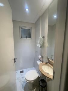 een witte badkamer met een toilet en een wastafel bij Apartamento para COP30 in Ananindeua