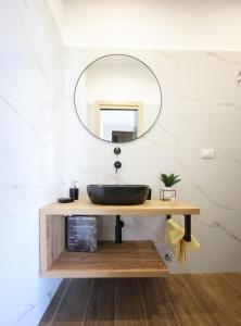 a bathroom with a black sink and a mirror at Regina Margherita Apartments in Avola