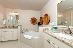 a bathroom with a tub and a sink and a mirror at South Bay Beach Club #24 - 4 Bedroom 4 Bathroom Unit in West Bay +16 photos