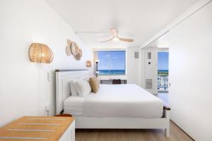 a white bedroom with a bed and a view of the ocean at Ilikai Marina Stunning Ocean & Harbor Views - Walk to the Beach! in Honolulu