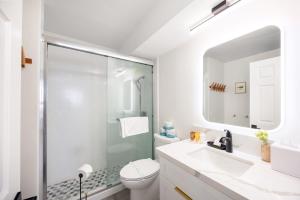 a bathroom with a shower and a toilet and a sink at Ilikai Marina Stunning Ocean & Harbor Views - Walk to the Beach! in Honolulu