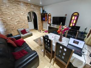 a living room with a couch and a table with a laptop at Recanto da Família in Cabo Frio