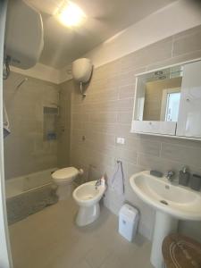 a bathroom with a toilet and a sink and a toilet istg at A due passi dalla spiaggia in Vieste