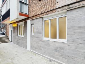 a facade of a brick building with windows at Bilbao ROOMS Etxebarria in Bilbao
