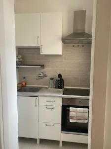 a kitchen with white cabinets and a stove top oven at A due passi dalla spiaggia in Vieste