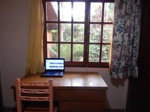 a laptop computer sitting on a desk in front of a window at Rincón verde in Eldorado