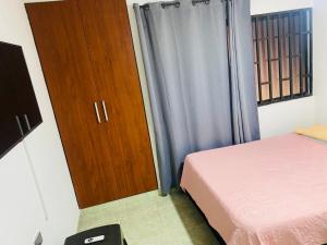 a bedroom with a bed and a wooden cabinet at Apartamento EURARE in Ríohacha