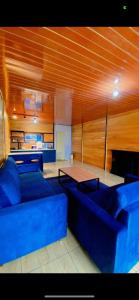 Una sala de estar con sofás azules y una mesa. en Cabin madinna, en Diyeng