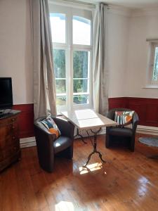 a living room with two chairs and a table and a window at Chateau prive, spa & 20ha,baie de somme mons boubert in Mons-Boubert