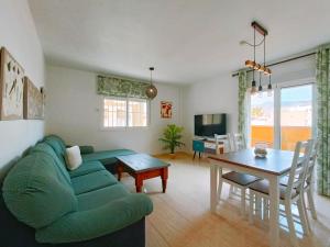 Una sala de estar con un sofá verde y una mesa. en El Jazmin Suites, 3 hab, gran terraza con vistas a la montaña y a 15 min de la playa, en Aguadulce