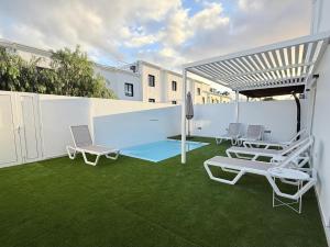 a patio with two chairs and a table and chairs at Villa Tiffany in Puerto del Carmen