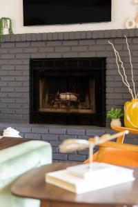 a living room with a brick fireplace with a tv at Mid-Century Flagstaff Mtn Condo in Flagstaff +32 photos