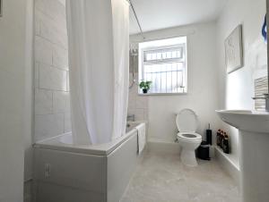 a bathroom with a tub and a toilet and a sink at Modern Apartment Near Manchester City Centre in Manchester