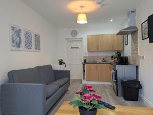 a living room with a couch and a kitchen at Modern Apartment Near Manchester City Centre in Manchester
