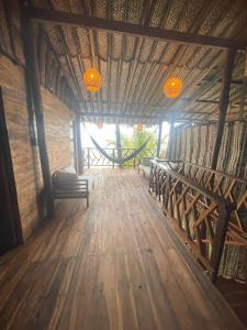 a room with a wooden floor and benches and lights at Puerto Manglar Hostal in Guachaca