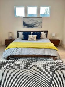 a large bed in a bedroom with two windows at Mountain Retreat in the Pines in Flagstaff