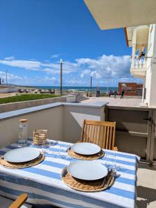 a table with a blue and white table cloth with a view of the beach at Paredes da Vitória - Surf & Sun in Pataias