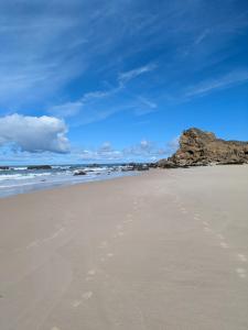 a sandy beach with footprints in the sand at Paredes da Vitória - Surf & Sun in Pataias +3 photos