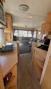 eine Küche und ein Wohnzimmer eines Wohnmobils in der Unterkunft Promenade park 8 Berth caravan next to the beach entrance, WIFI included in Ingoldmells + 3 Fotos