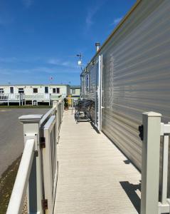 einen Gehweg neben einem Gebäude mit einer Metallwand in der Unterkunft Promenade park 8 Berth caravan next to the beach entrance, WIFI included in Ingoldmells