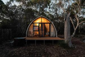 a small dome tent with a table and a tree at Eco Luxury - Heated - Hot Tub - Waterfront - Freycinet in Coles Bay
