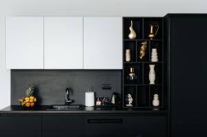 a kitchen with a black counter and white cabinets at Apartments Museum in Sarajevo
