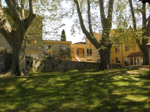 a large yellow house with trees in the yard at Le Moulin de César in Vaison-la-Romaine