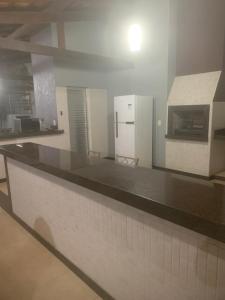 a kitchen with a counter and a refrigerator at Chalés da Zelma in Capitólio
