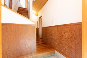 a hallway with wood paneling and stairs in a house at Green Oasis Cottage A in Hakone