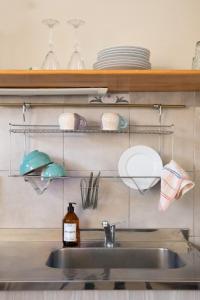 a kitchen sink with dishes on a shelf above it at Casita del centro Esquel luz natural, wifi alto, ideal parejas, check in autónomo in Esquel