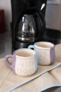 two cups of coffee sitting on top of a counter at Casita del centro Esquel luz natural, wifi alto, ideal parejas, check in autónomo in Esquel +25 photos