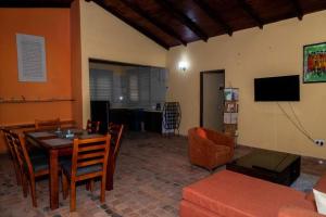 a living room with a table and chairs and a television at Mi Casa, Your Cozy Stay in Koforidua
