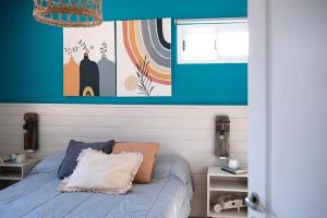 a bedroom with a bed and a blue wall at Casita del centro Esquel luz natural, wifi alto, ideal parejas, check in autónomo in Esquel