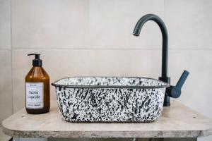 a black and white bowl and a sink with a bottle of soap at Casita del centro Esquel luz natural, wifi alto, ideal parejas, check in autónomo in Esquel