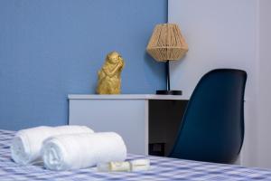 a statue of a monkey sitting on a bed with towels at Live Oporto Rooms in Porto