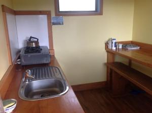 a kitchen with a sink and a stove at Freestone Cabins in Manapouri