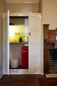 a kitchen with a red refrigerator and a open door at Bank-sia accommodation in Mount Barker