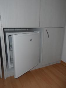 a small white refrigerator under a cabinet in a room at Anemones Rooms in Chania